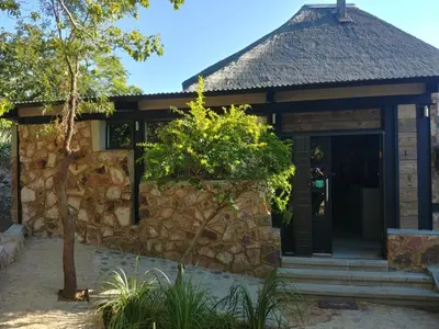 a stone house with a stone wall at Sky Lodge in Hartbeespoort