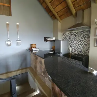 a kitchen with a black counter top in a room at Sky Lodge in Hartbeespoort