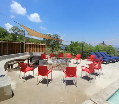a group of chairs and a table and a fire pit at Sky Lodge in Hartbeespoort