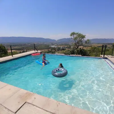 a couple of people in a swimming pool at Sky Lodge in Hartbeespoort