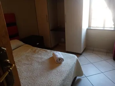 a room with a bed with a towel on it at Ebony Guest House in Pretoria