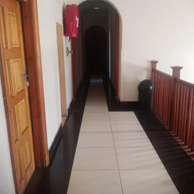 a hallway leading to a hallway with a red fire extinguisher at Ebony Guest House in Pretoria