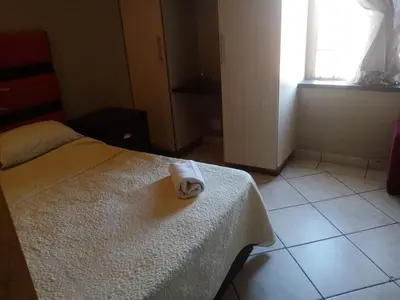 a room with a bed with a towel on it at Ebony Guest House in Pretoria