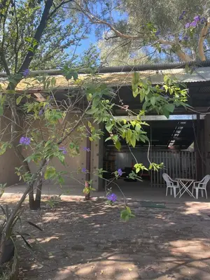 a building with a table and chairs in a yard at Pringle Cottage in Benoni