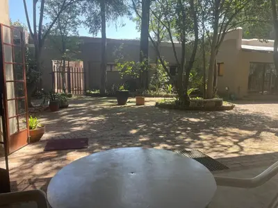 a table in the middle of a courtyard at Pringle Cottage in Benoni