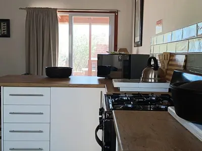 a kitchen with a stove and a microwave at Sunset on Kingfisher in Marloth Park