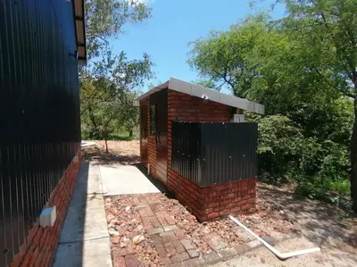 a brick house with a gate on the side of it at Sunset on Kingfisher in Marloth Park
