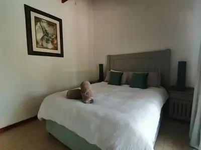 a stuffed animal sitting on a bed in a bedroom at Sunset on Kingfisher in Marloth Park