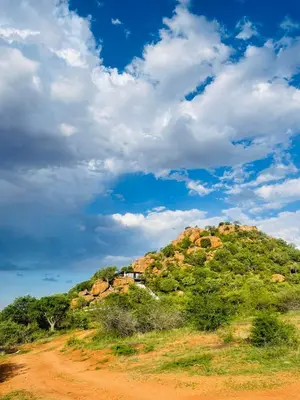 a house on a hill on a dirt road at Makgobelo Lodge-The Glass House- Solar powered in Ga-Mokalapa