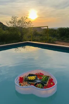 a tray of food sitting in the middle of a swimming pool at Makgobelo Lodge-The Glass House- Solar powered in Ga-Mokalapa
