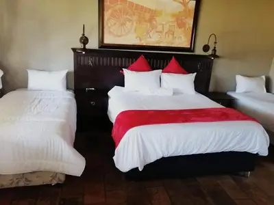 a bedroom with two beds with white and red pillows at Pioneer lodge in Lephalale