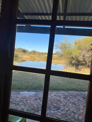 a window view of a lake from a house at Pioneer lodge in Lephalale