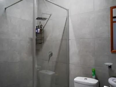 a bathroom with a shower and a toilet at Aqua Guest House in Sandown