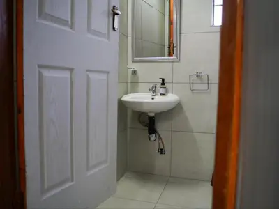 a bathroom with a white sink and a mirror at Aqua Guest House in Sandown