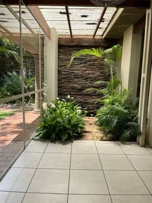a patio with plants in front of a building at Red Cascade - Luxury 4 bedrooms -solar and aircons in Hartbeespoort