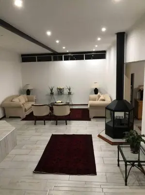 a living room with couches and a fireplace at Red Cascade - Luxury 4 bedrooms -solar and aircons in Hartbeespoort
