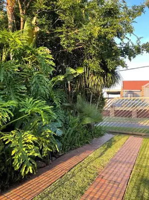 a garden with a brick walkway with plants and trees at Red Cascade - Luxury 4 bedrooms -solar and aircons in Hartbeespoort