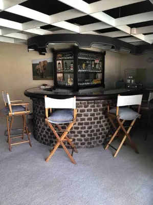 a bar with two chairs in front of a counter at Red Cascade - Luxury 4 bedrooms -solar and aircons in Hartbeespoort
