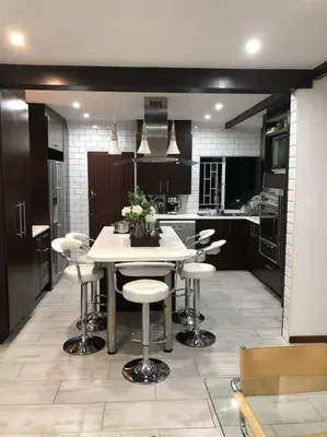 a kitchen with a table and stools in it at Red Cascade - Luxury 4 bedrooms -solar and aircons in Hartbeespoort