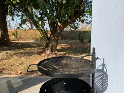 a black picnic table sitting next to a tree at ilanda Guest House in White River
