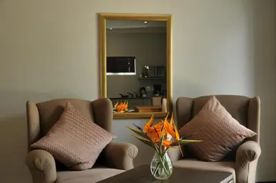 a living room with a couch and a mirror at ilanda Guest House in White River
