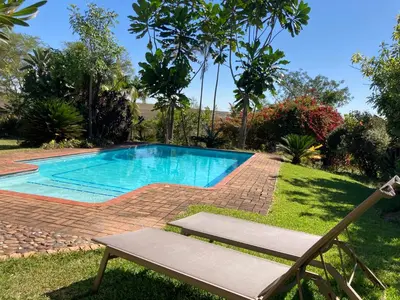 a swimming pool in a yard with a bench at ilanda Guest House in White River