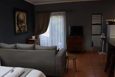 a living room with a couch and a window at Studio in Lynnwood garden estate in Pretoria