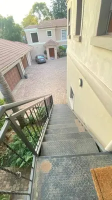 a stairway leading up to a house with a car at Studio in Lynnwood garden estate in Pretoria