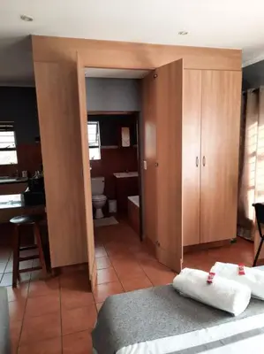 a room with a bedroom with a bathroom with a toilet at Studio in Lynnwood garden estate in Pretoria
