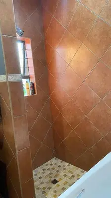 a bathroom with a shower with brown tile at Studio in Lynnwood garden estate in Pretoria