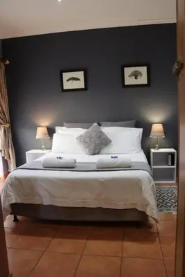 a bedroom with a large bed with two lamps at Studio in Lynnwood garden estate in Pretoria