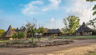 a village with houses and a dirt road at Wildside Safari Camp in Golders Green