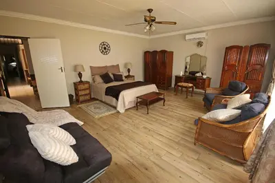 a bedroom with a bed and a couch and chairs at Clartal's Place in Isidule