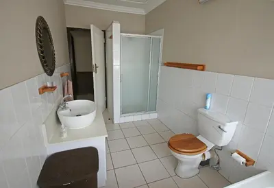 a bathroom with a toilet and a sink and a shower at Clartal's Place in Isidule