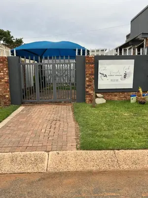 a metal gate with a sign on a fence at Kiewiets Cradle Guest House in Pretoria