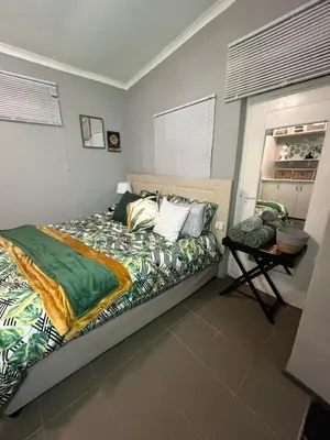 a bedroom with a bed and a table in it at Kiewiets Cradle Guest House in Pretoria