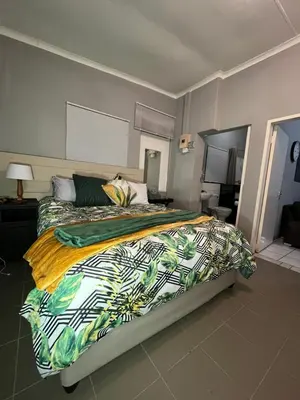 a bedroom with a large bed with a colorful comforter at Kiewiets Cradle Guest House in Pretoria