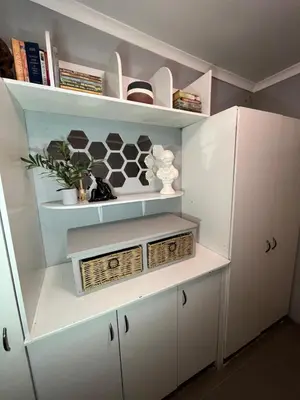 a white kitchen with white cabinets and shelves at Kiewiets Cradle Guest House in Pretoria