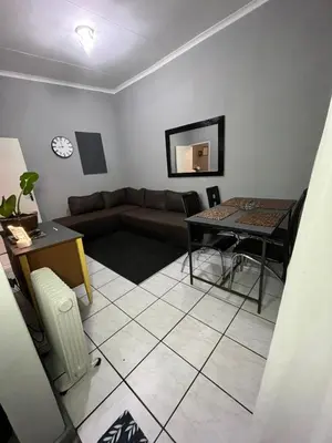 a living room with a couch and a table at Kiewiets Cradle Guest House in Pretoria