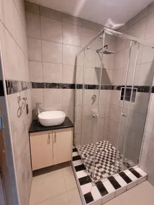 a bathroom with a shower and a sink at Okoli's Place in Sandown