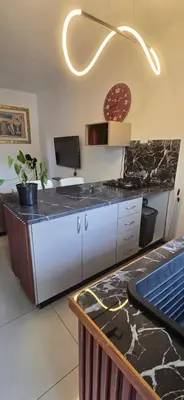 a kitchen with a counter with a sink and a counter top at Okoli's Place in Sandown