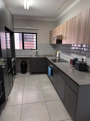 a large kitchen with gray counters and a counter top at Large 3 Bedroom Apartment in Midrand, Waterfall City - More space than a hotel room - Ideal for families, groups and work trips - 18A Elizabeth Place in Midrand