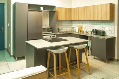 a kitchen with a island with bar stools in it at Spacious 2 Bedroom Apartment in Midrand, Waterfall City - Business and Family friendly - 14A Elizabeth Place in Midrand