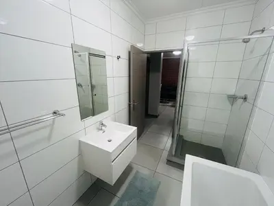 a white bathroom with a sink and a shower at Spacious 2 Bedroom Apartment in Midrand, Waterfall City - Business and Family friendly - 14A Elizabeth Place in Midrand