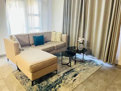a living room with a couch and a table at Secure 1 Bedroom Apartment in Midrand, Waterfall City - Lock Up and Go - Free WIFI and Parking - 6A Elizabeth Place in Midrand