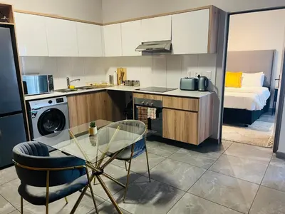 a small kitchen with a table and a bed at Secure 1 Bedroom Apartment in Midrand, Waterfall City - Lock Up and Go - Free WIFI and Parking - 6A Elizabeth Place in Midrand