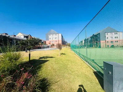 a tennis court in front of some buildings at Secure 1 Bedroom Apartment in Midrand, Waterfall City - Lock Up and Go - Free WIFI and Parking - 6A Elizabeth Place in Midrand