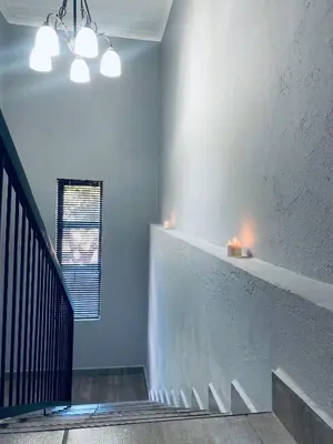 a hallway with a staircase with lights on the wall at 23 On Jupiter in Polokwane