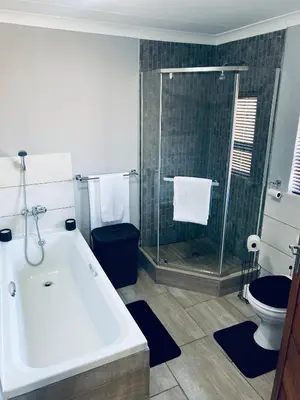 a bathroom with a tub and a shower and a toilet at 23 On Jupiter in Polokwane