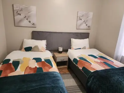 a bedroom with two beds and a teddy bear between them at Sable woods in Pretoria